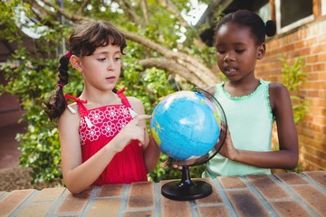 Poster - Girls pointing at a globe