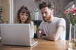 © fStop - Young couple looking at laptop on table