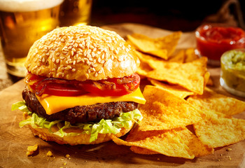 Cheeseburger with beer and nacho snacks