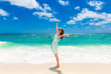 Young beautiful Asian  girl in blue dress on the beach of a trop