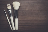 Fototapeta Sypialnia - white make-up brushes on brown wooden background