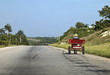 © robertharding - Man driving horse and cart on a wide deserted country road, Cuba