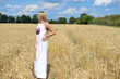 © gorosi - Full side length of beautiful young lady in white dress, wheat field