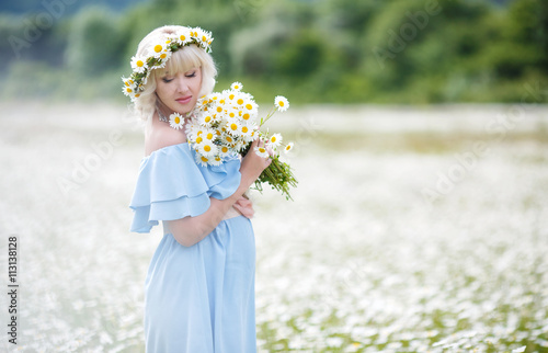 Spring Portrait Of A Pregnant Woman On A White Field Of