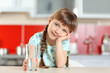 © Africa Studio - Cute little girl holding glass of water in kitchen