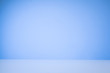 Blue gradient background with a white, reflective desk surface.