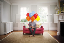 Man Sitting On Couch With Balloons