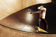 Young Man Skateboarding In Skateboard Park