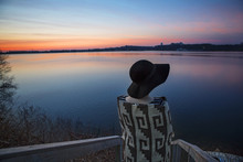 Woman Wrapped In Blanket Looking At Lake During Sunset In Winter