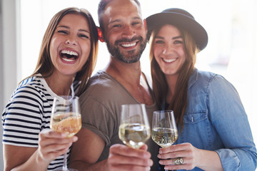 Wall Mural - Three laughing friends with wine glasses