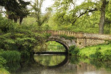 Stunning landscape image of old medieval bridge over river with