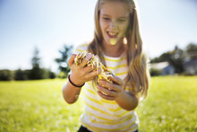 Happy Girl Holding Pumpkin Pulp On Field During Summer