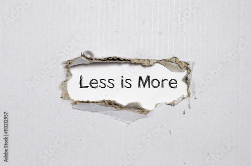 Fotografía The word less is more appearing behind torn paper.