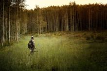 Bow Hunter Walking Across Grassy Glade