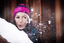 Portrait Of Young Woman Blowing Snow