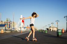 Young Woman Roller Skating On Road