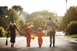 © Cavan Images - Rear view of a family dressed up in costume for Halloween