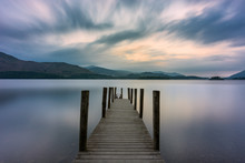 Wooden Jetty Leading Out Into Lake With Dramatic Clouds In Sky. Ashness, Derwentwater, Keswick, Lake District, UK.