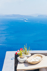 Wall Mural - Volcanic caldera and traditional architecture detail, stones and plants on balcony on a house in Oia village, Santorini