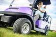 Mature man smiling while driving golf cart