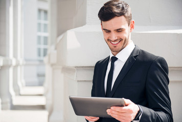 Cheerful man using tablet