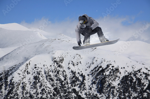 Cuadros en Lienzo Corredor de snowboard que salta sobre las montañas