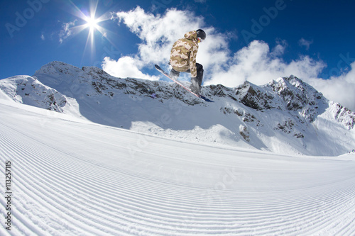 Fotografía Corredor de snowboard que salta sobre las montañas