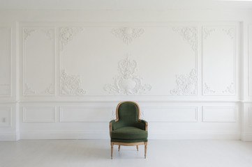 Living room with antique stylish green armchair on luxury white wall design bas-relief stucco mouldings roccoco elements