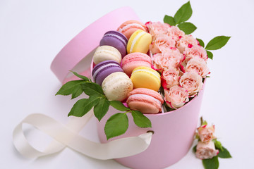 Wall Mural - Tasty macaroons and roses in box on light background