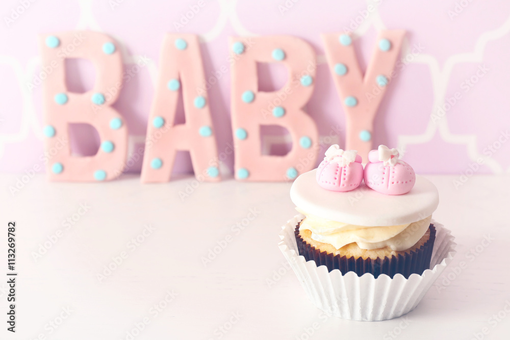 Word "Baby" with cupcake on bright background