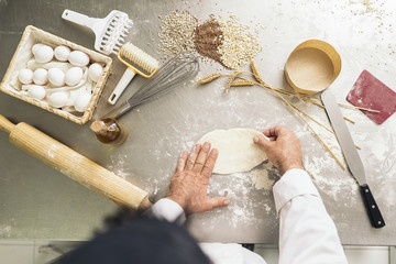 Baker kneading dough in a bakery.