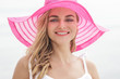 beautiful woman smiling and wearing pink sunhat
