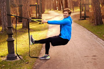 Wall Mural - Sporty male exercising with fitness trx.