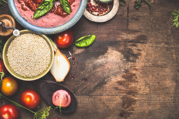 Wall Mural - Dry quinoa with tomatoes and cooking ingredients on dark wooden background, top view, border, place for menu or recipe