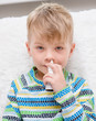 © Ermolaev Alexandr - ill boy with flu using nose spray
