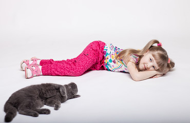 pretty little girl lying on the floor with her cat