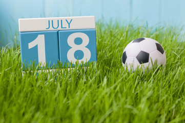 Wall Mural - July 18th. Image of july 18 wooden color calendar on greengrass lawn background. Summer day, empty space for text