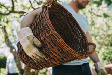 Midsection Of Man Carrying Wicker Basket At Yard