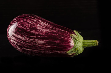 Fresh purple eggplant with waterdrops isolated on black backgrou