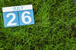 July 26th. Image of july 26 wooden color calendar on greengrass lawn background. Summer day, empty space for text
