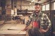 © Nejron Photo - Carpenter posing on his workplace in carpentry workshop.