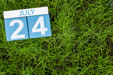 Wall Mural - July 24th. Image of july 24 wooden color calendar on greengrass lawn background. Summer day, empty space for text