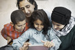 © Maskot - Muslim family using digital tablet together at home