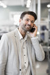 © Maskot - Smiling businessman answering mobile phone in manufacturing plant