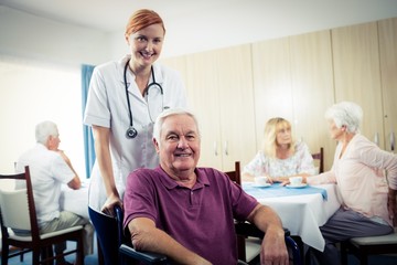 Wall Mural - Portrait of a nurse with senior man in wheelchair