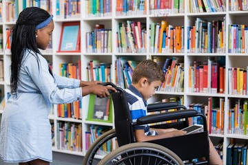 Wall Mural - Schoolgirl pushing a boy on wheelchair 