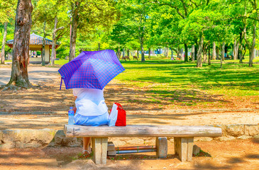 Relaxing seated in the park with water bottle and sun umbrella