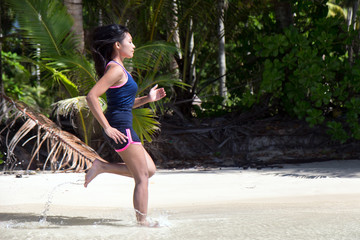 Wall Mural - woman running in sea water on the coast