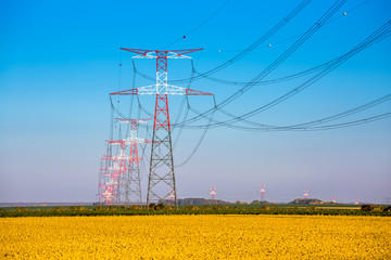 Electricity transmission pylon silhouetted against blue