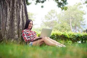 Sticker - Young beautiful woman with laptop in the garden on summer day